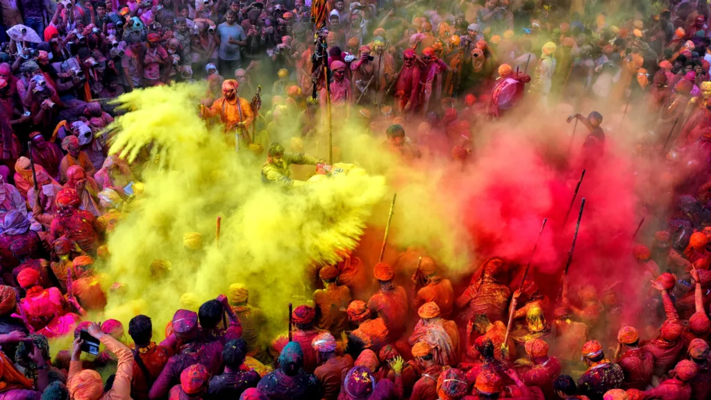 Picture of colourful powders being thrown over the crown during the Festival of Colors in Holi, India.