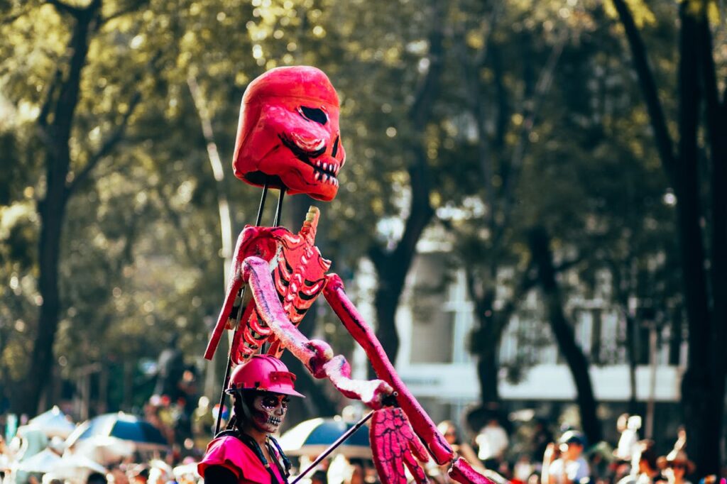 Woman Dressed as a Catrina Holding a Skeleton Decoration during a Day of the Dead Parade