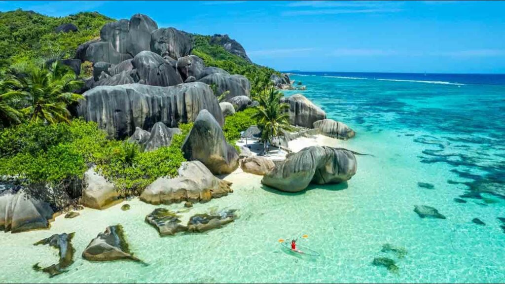 Picture of woman on a transparent canoe on Anse Source d'Argent beach on sunny day