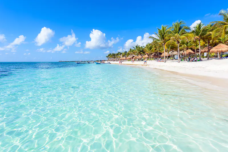 Beautiful sunny day on Tulum Beach with people swimming and basking in the sun